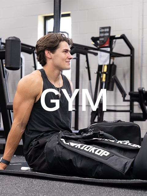 Athlete seated in a gym wearing KIOKOP compression boots