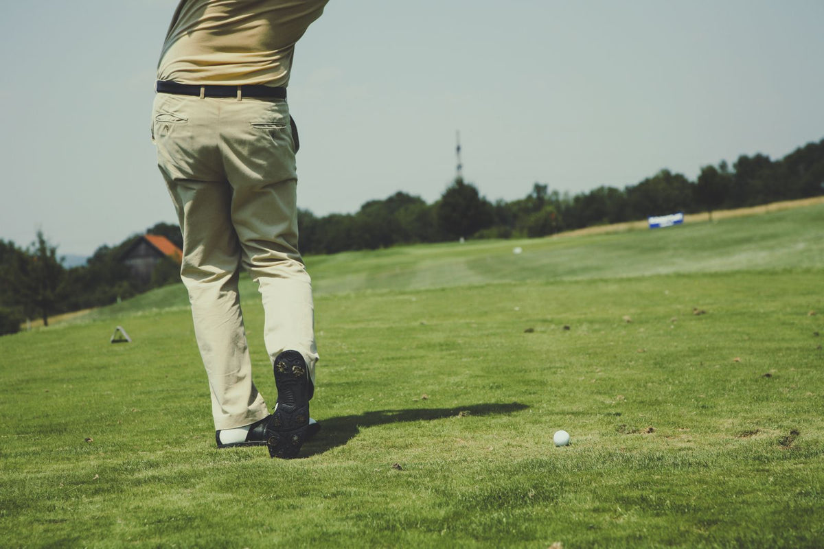 Golfer making a swing on an outdoor golf course