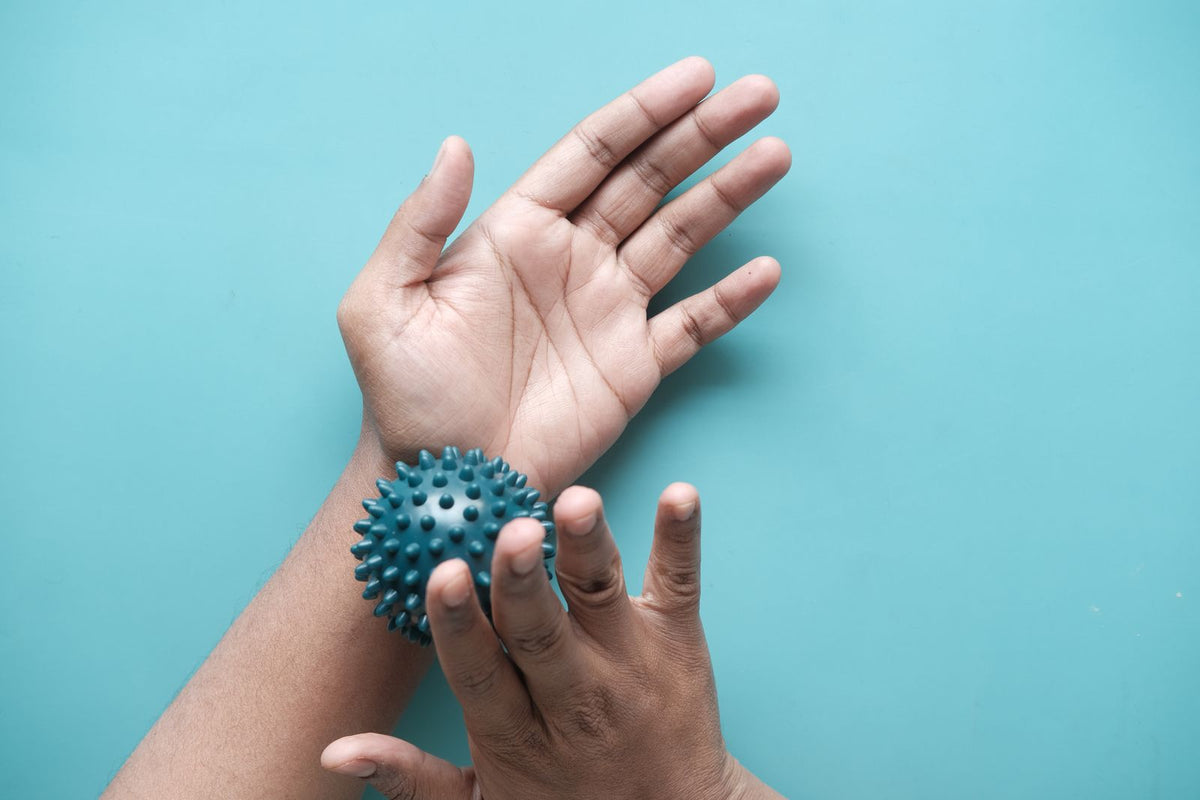 Hands holding a textured massage ball
