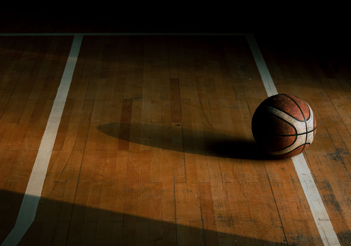 Basketball resting on a wooden indoor court