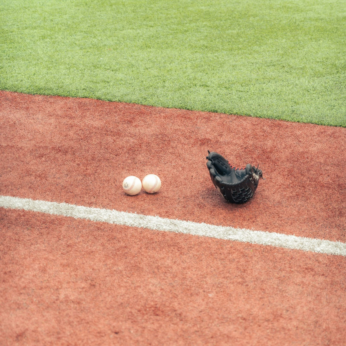 Baseball glove and balls on a field