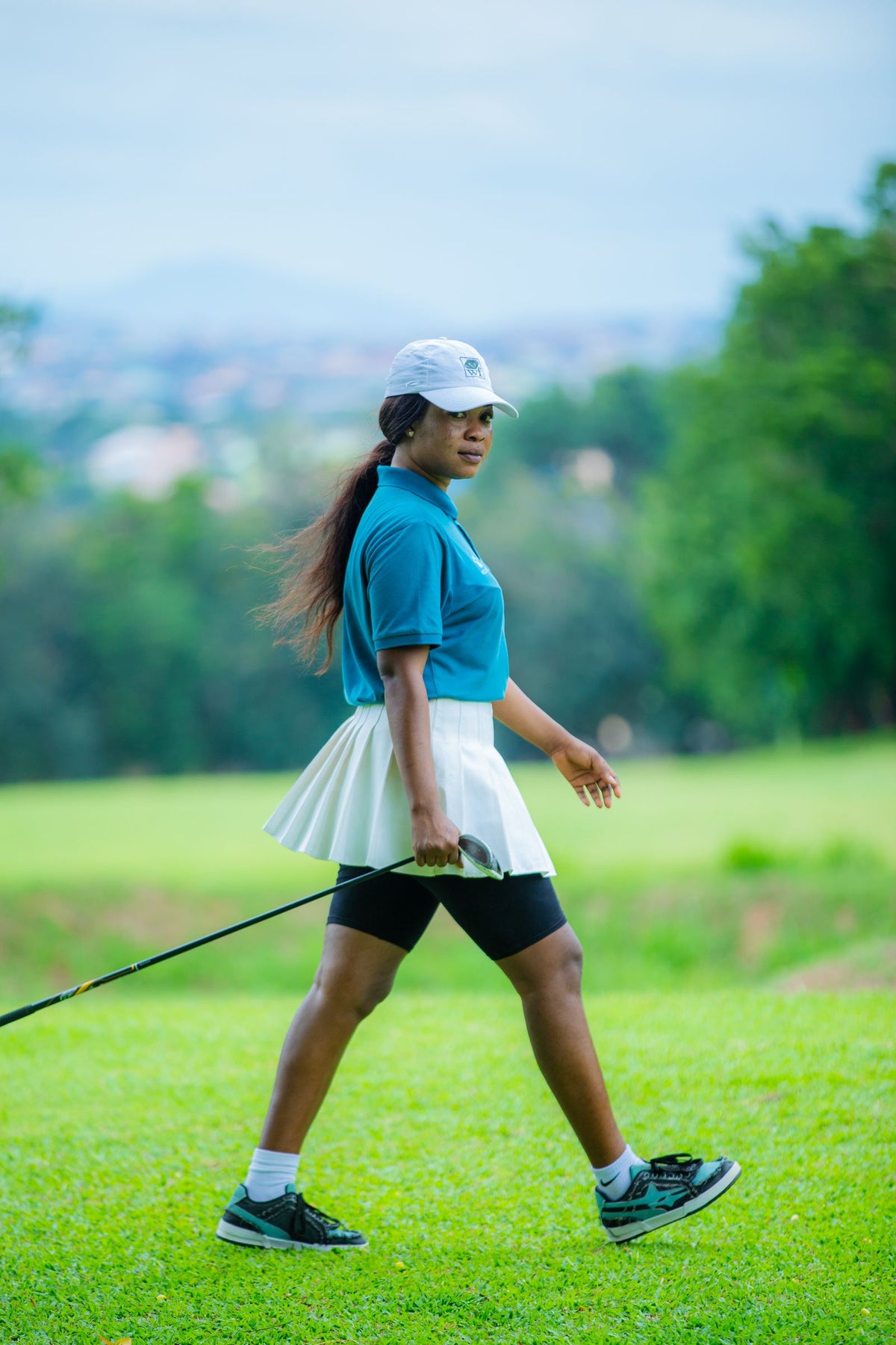 Golfer walking across a green course