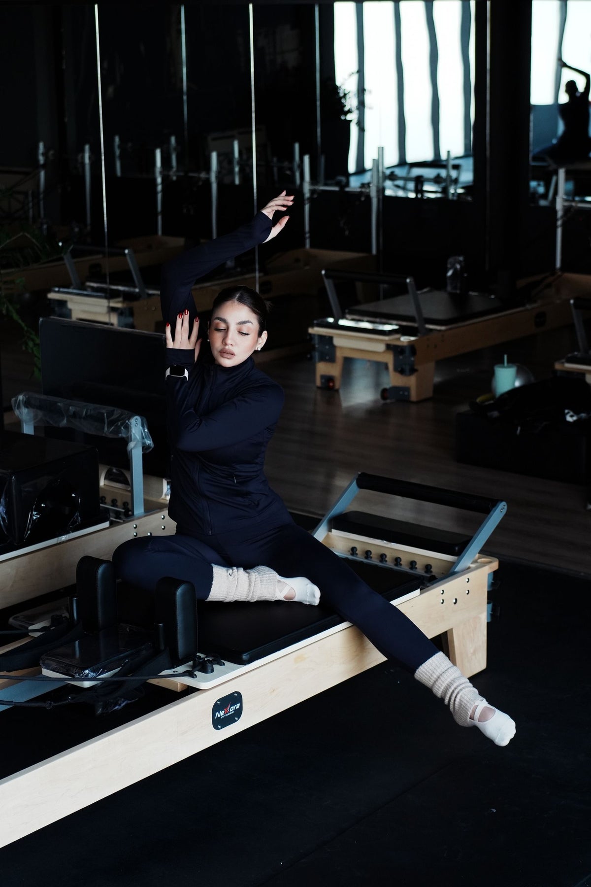Woman exercising on a Pilates reformer in a studio