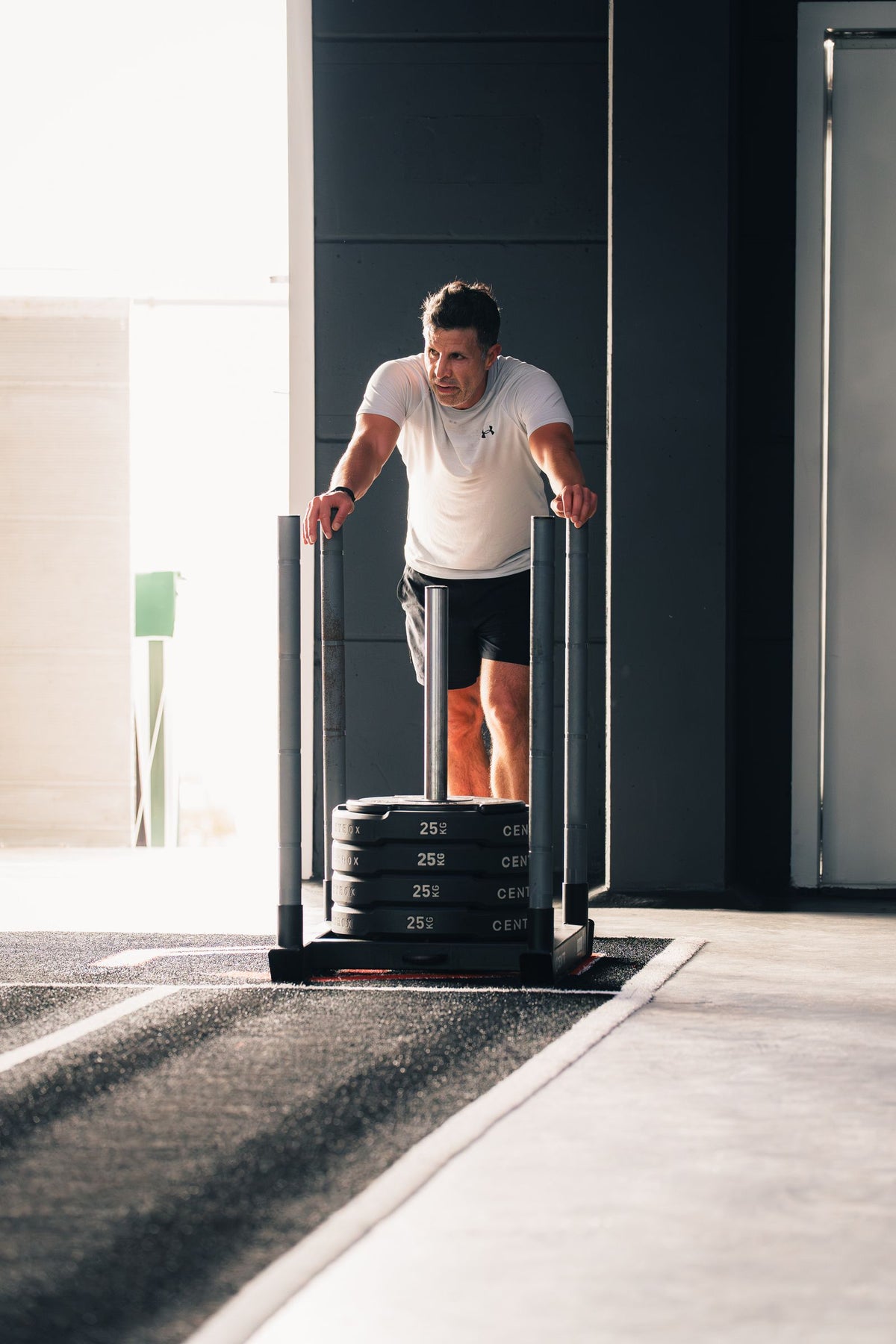 Athlete pushing a weighted sled during gym training