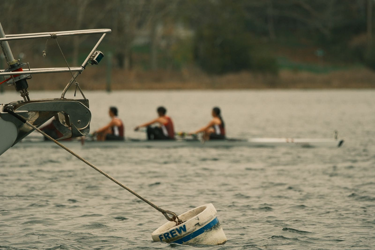 Rowing crew on the water near moored boats