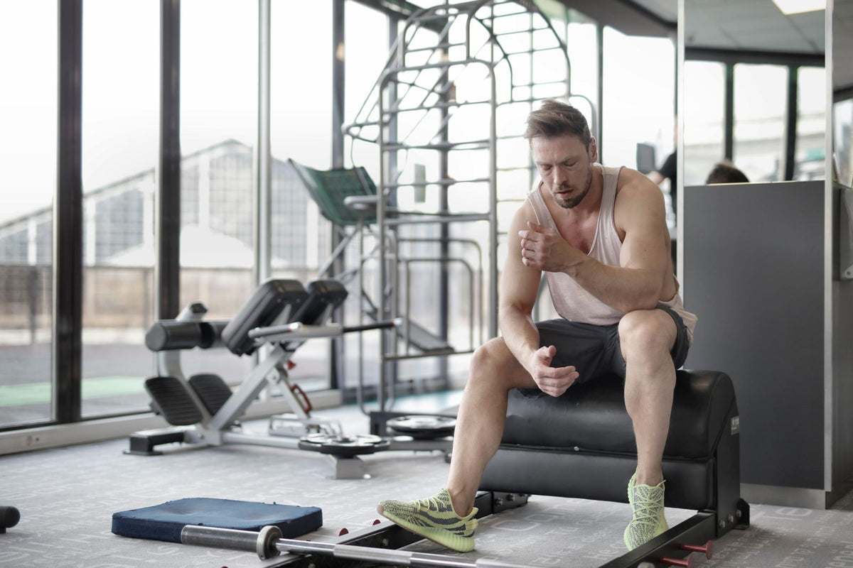 Man in sportswear sitting on a bench in a gym