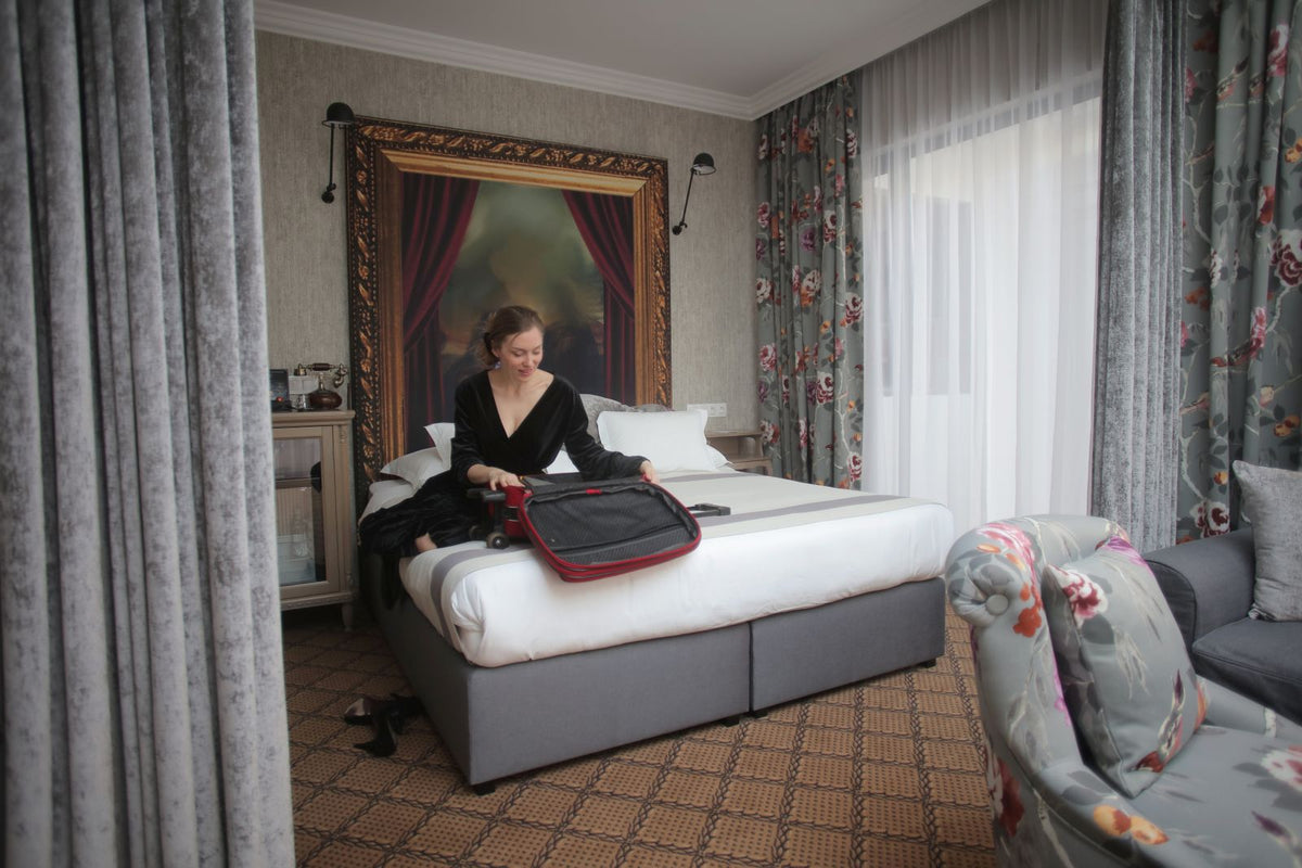 Traveller organizing a suitcase in a hotel room