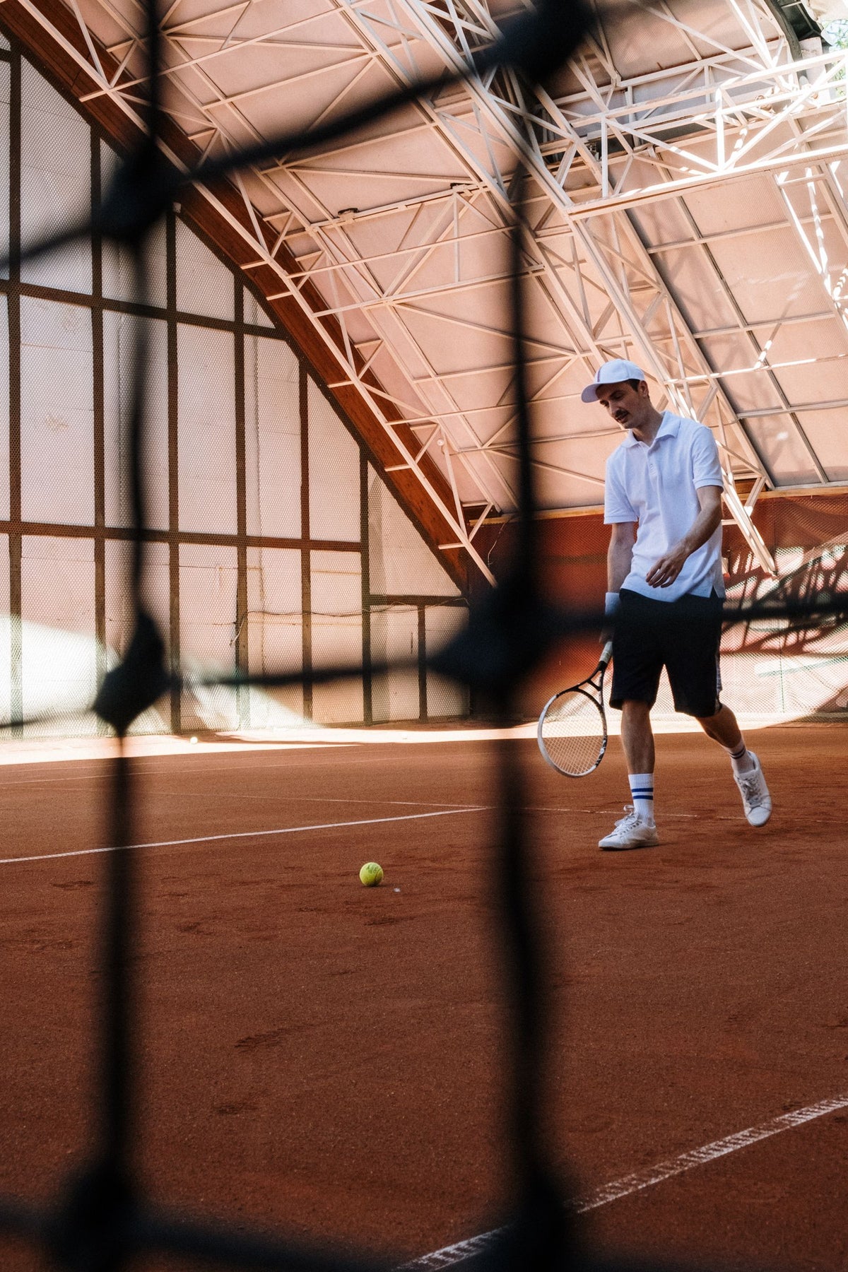 Tennis player preparing for a shot on an indoor clay court