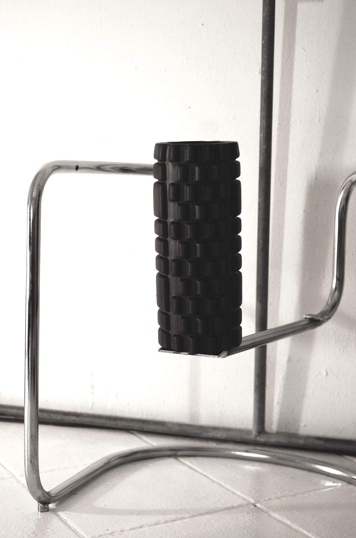 Textured foam roller resting on a metal stand