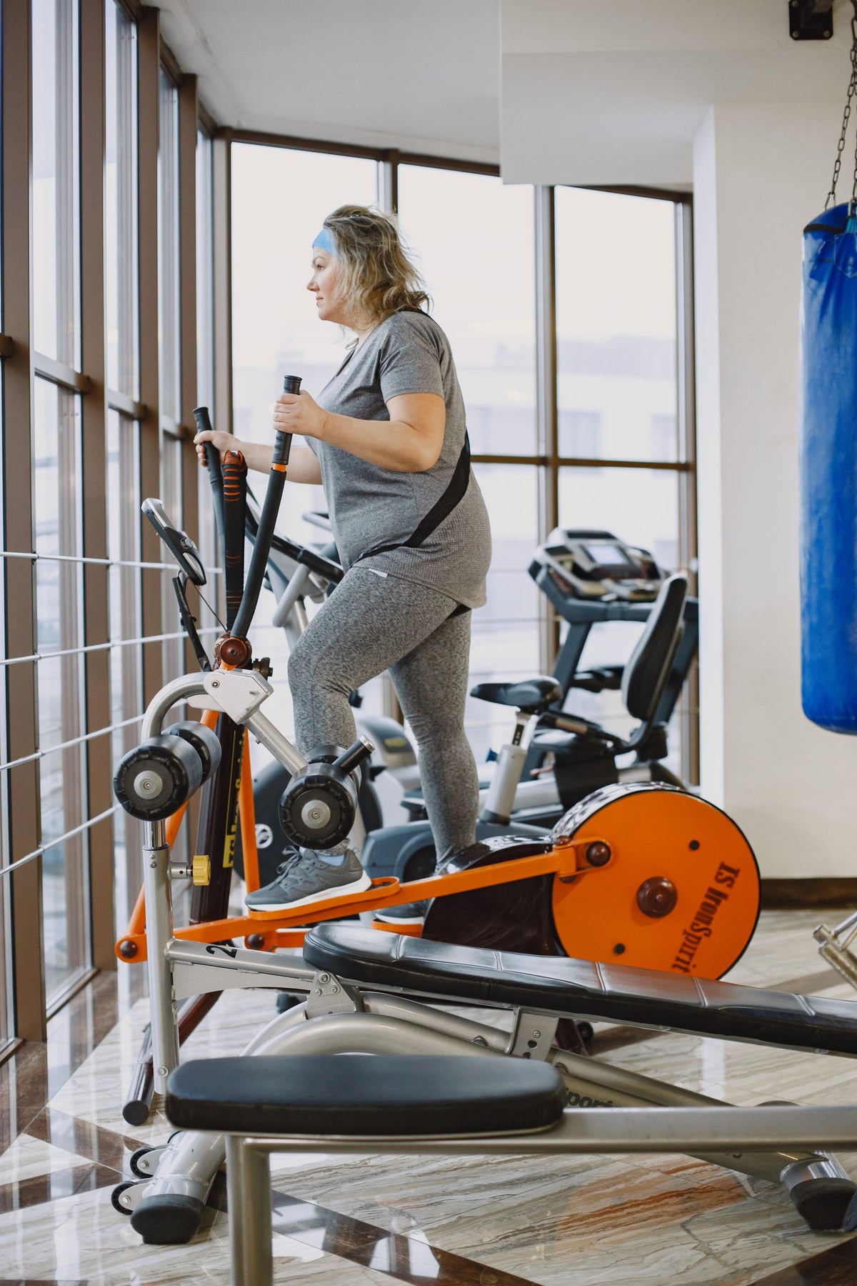 Woman using an elliptical trainer in a gym