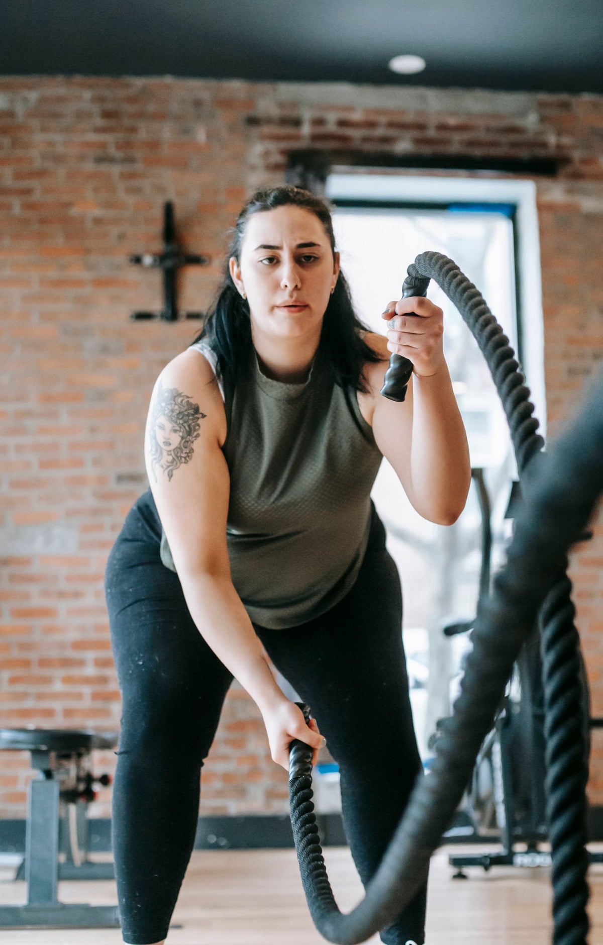Woman exercising with battle ropes in a gym