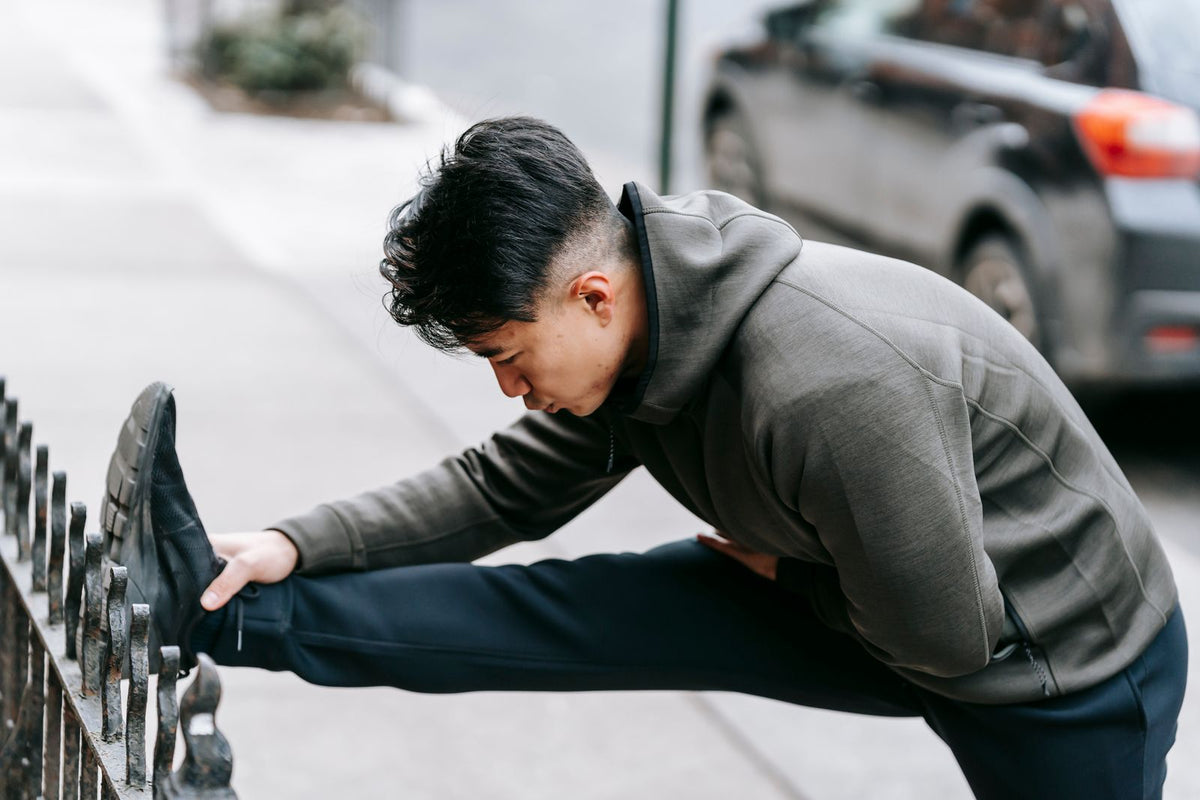 Runner stretching outdoors on a park path