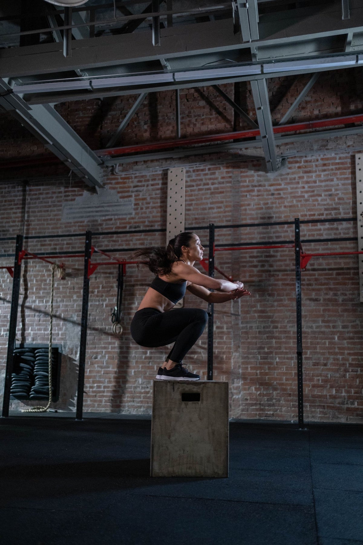Athlete performing a box jump in a gym