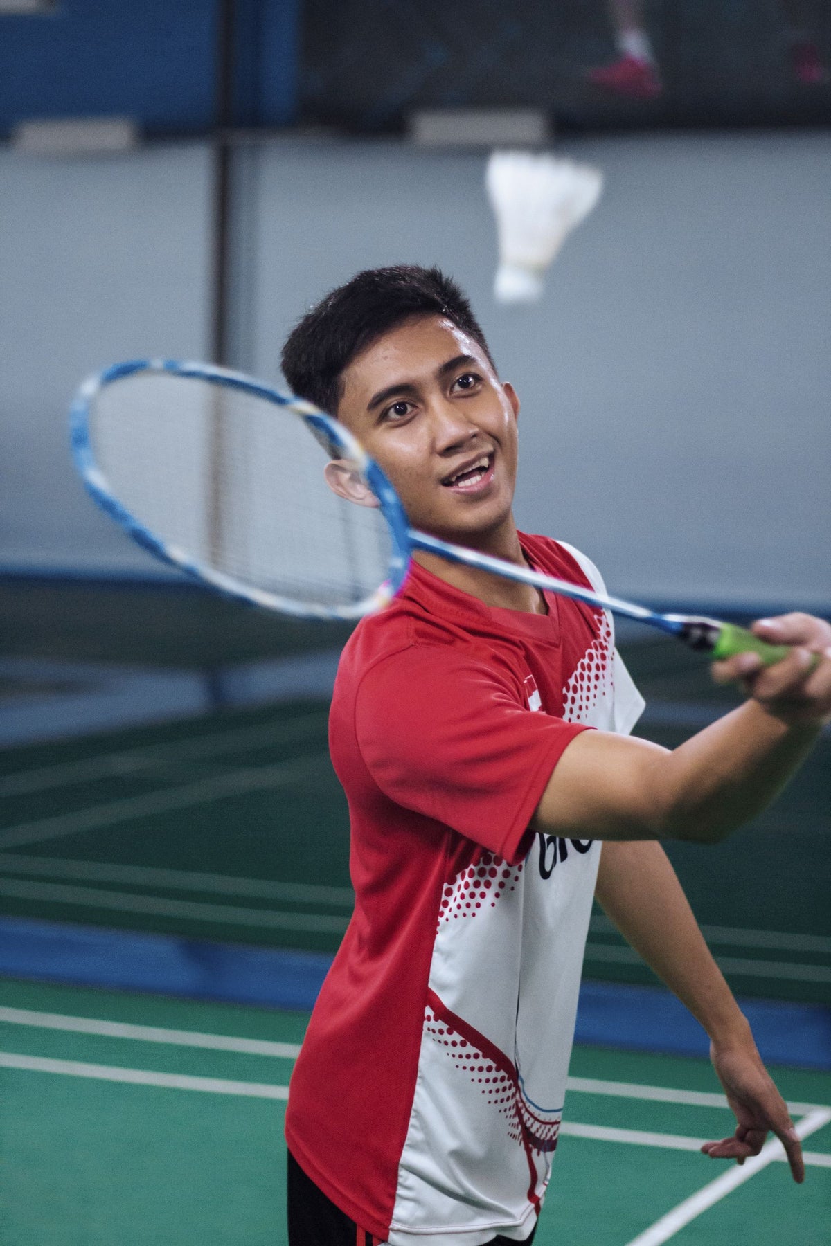 Badminton player holding a racket on an indoor court