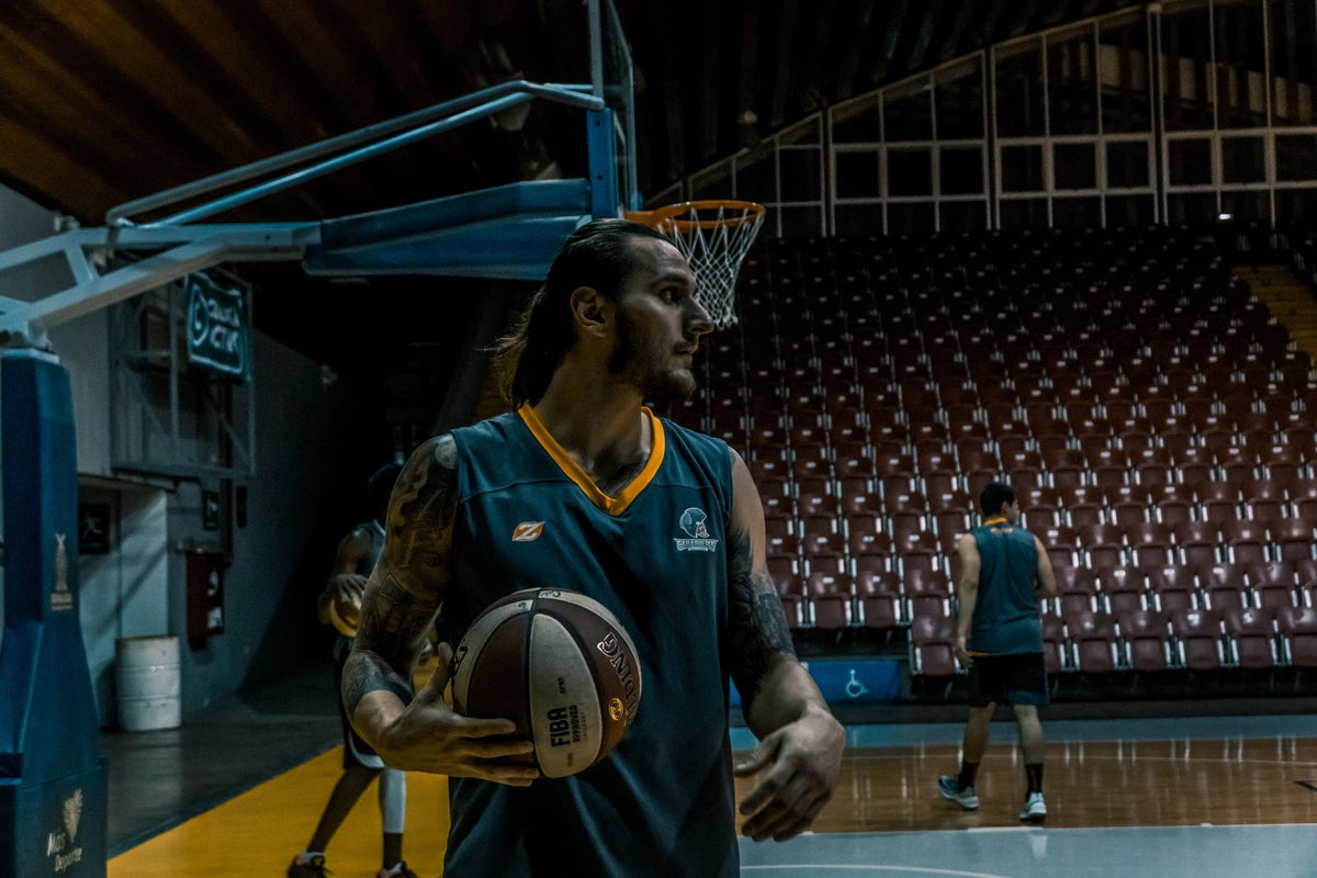 Basketball players with balls in an indoor gym